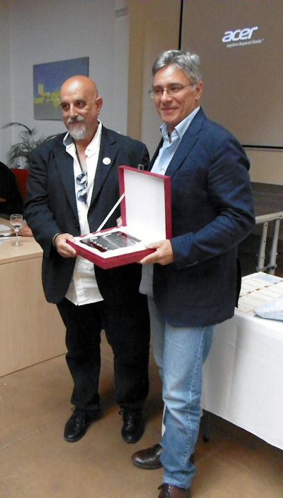 El alcalde, Juan Casanova, entrega un reconocimiento al diseñador de la cubierta del libro, Juanjo Trujillo.