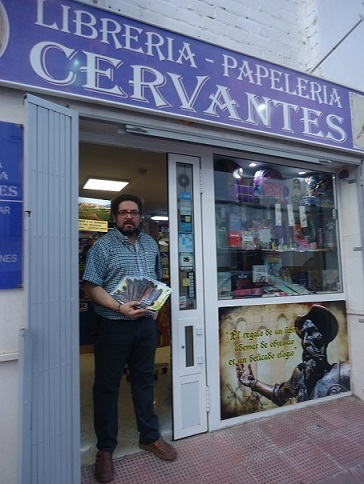 El librero de Librerí­a Cervantes muestra ejemplares de Un paseo por Ronda.